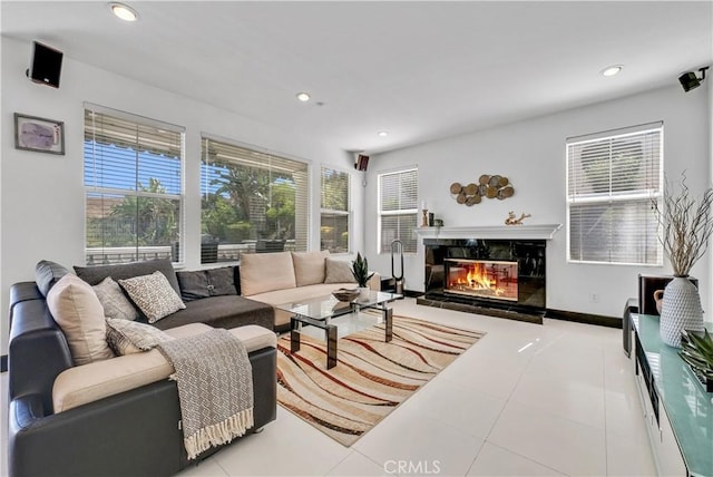 living room featuring a premium fireplace and light tile patterned floors