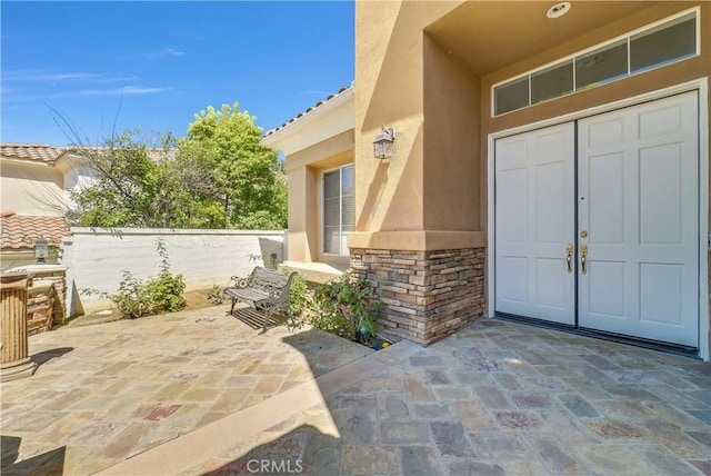 view of exterior entry featuring a patio area