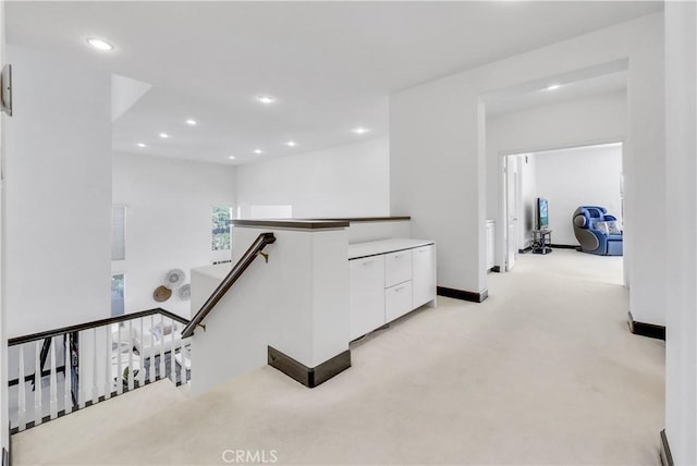 hallway featuring light colored carpet