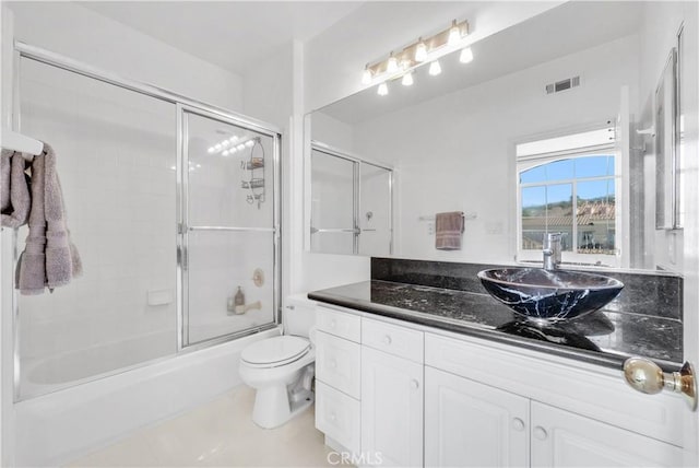 full bathroom with vanity, toilet, and combined bath / shower with glass door