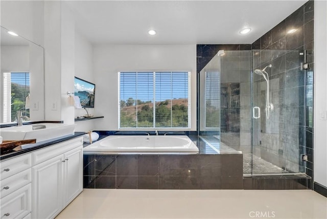 bathroom featuring vanity and independent shower and bath