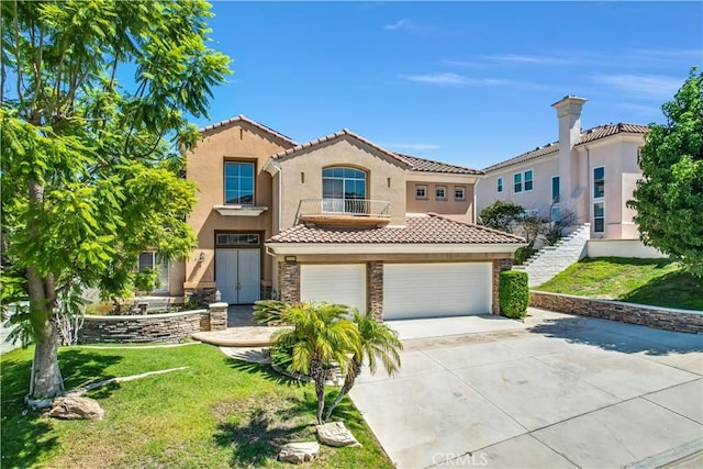 mediterranean / spanish-style home with a balcony, a garage, and a front yard