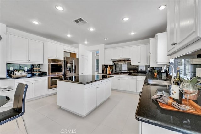 kitchen with appliances with stainless steel finishes, a center island, sink, and white cabinets