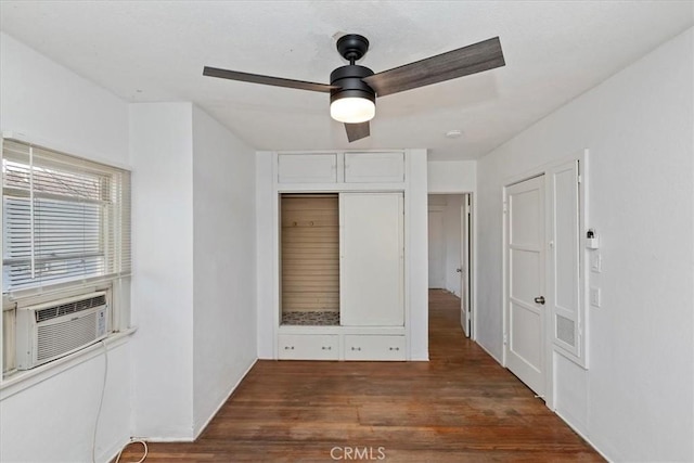 empty room featuring cooling unit, dark wood-type flooring, and ceiling fan