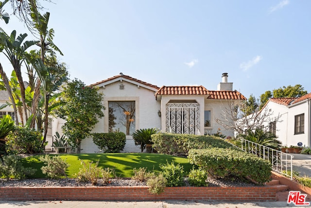 mediterranean / spanish home featuring a front lawn