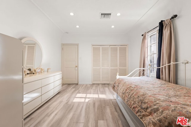 bedroom with light hardwood / wood-style floors and a closet