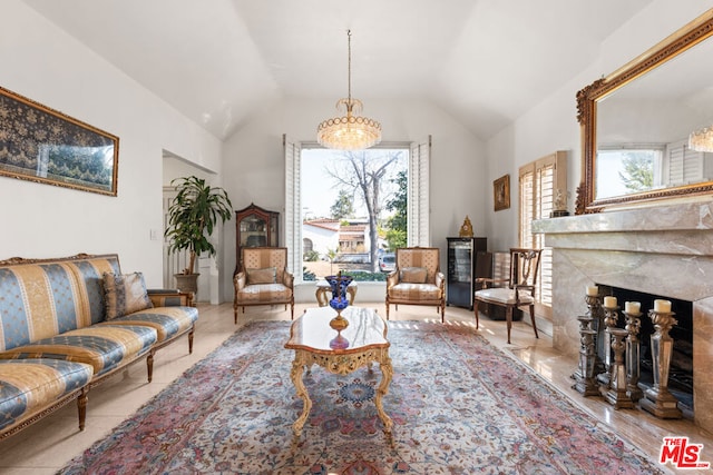 sitting room with vaulted ceiling, a premium fireplace, and a healthy amount of sunlight