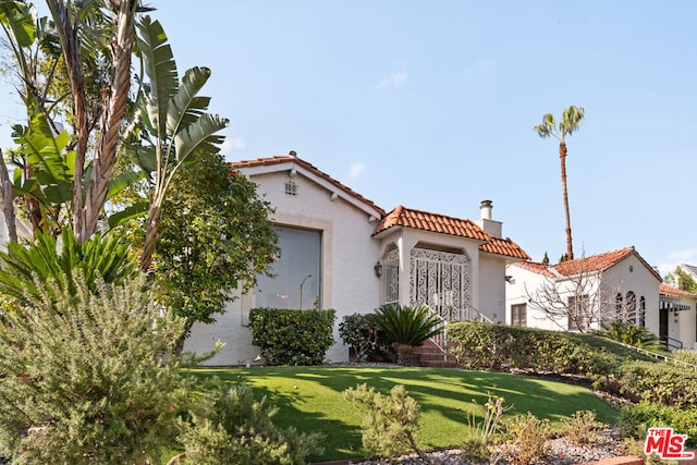 mediterranean / spanish-style house featuring a front lawn