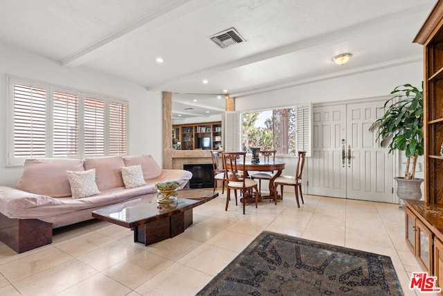 living room with beam ceiling and light tile patterned flooring