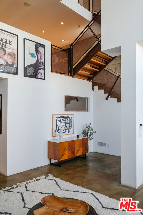 stairway with concrete floors and a high ceiling