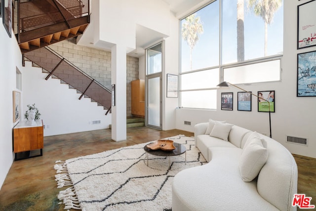 living room with a high ceiling and concrete floors