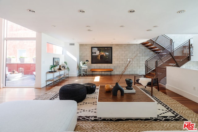 living room with hardwood / wood-style floors, a fireplace, and a wall of windows