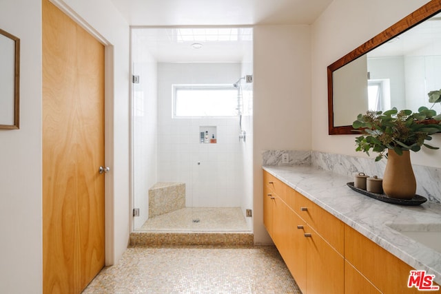 bathroom with vanity and tiled shower