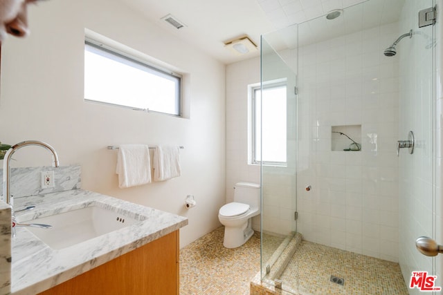 bathroom featuring walk in shower, vanity, and toilet