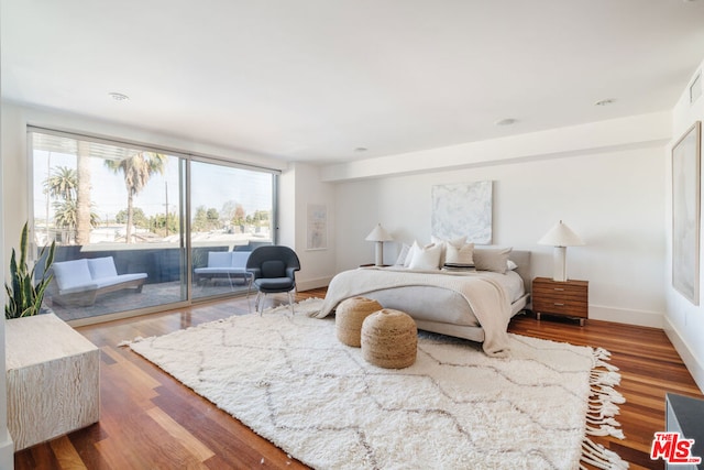 bedroom with hardwood / wood-style flooring and access to exterior