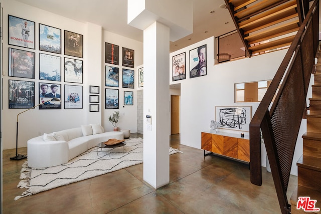 living area featuring decorative columns and a high ceiling