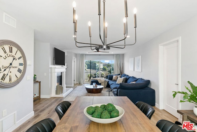 dining room with a notable chandelier and light wood-type flooring