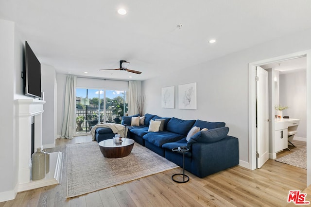 living room with ceiling fan and light hardwood / wood-style flooring