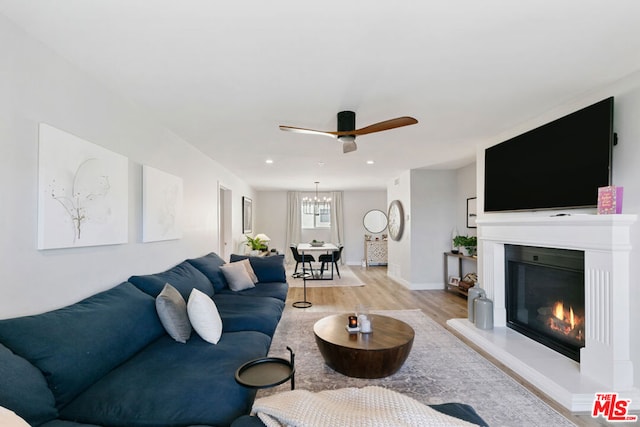 living room featuring ceiling fan and light hardwood / wood-style flooring