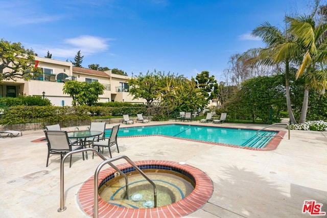 view of swimming pool with a hot tub and a patio