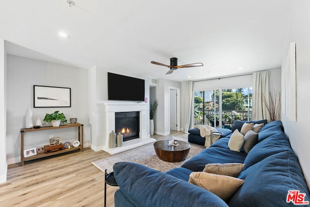 living room with ceiling fan and light hardwood / wood-style flooring