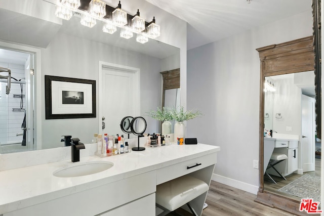 bathroom featuring walk in shower, wood-type flooring, and vanity