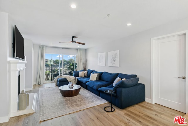 living room featuring light hardwood / wood-style flooring and ceiling fan