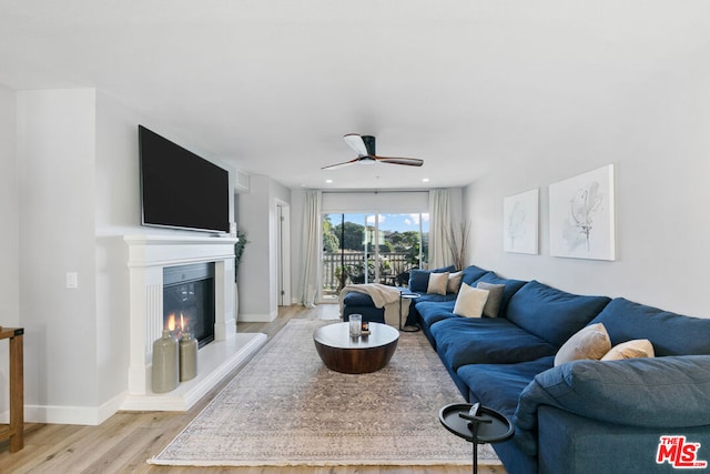 living room featuring ceiling fan and light wood-type flooring