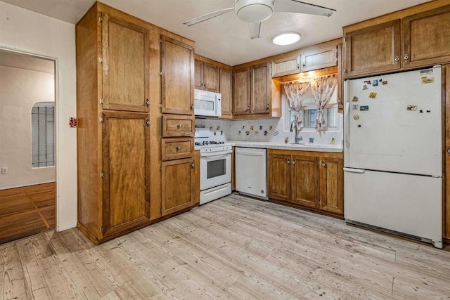 kitchen with ceiling fan, white appliances, sink, and light wood-type flooring