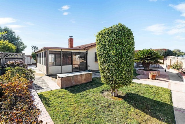 exterior space featuring a patio, a sunroom, and a front yard