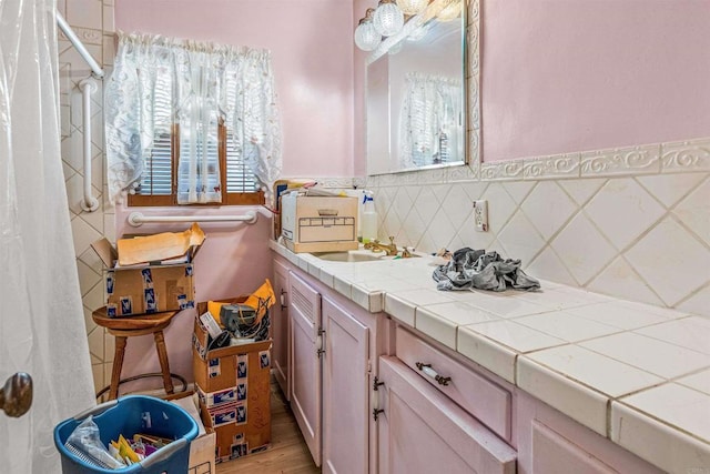 bathroom with tasteful backsplash, vanity, and hardwood / wood-style floors