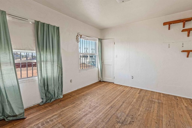 unfurnished room with hardwood / wood-style flooring and a wealth of natural light