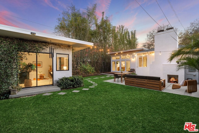 yard at dusk featuring outdoor lounge area and a patio area