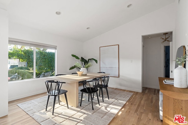 dining area featuring light hardwood / wood-style flooring and vaulted ceiling