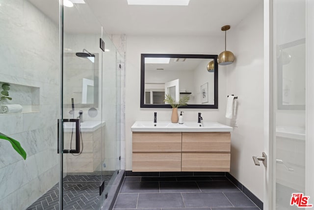 bathroom with a skylight, vanity, tile patterned flooring, and a shower with door