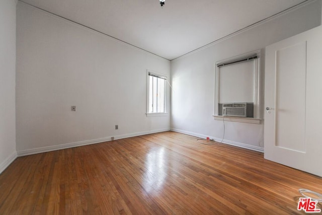 spare room with cooling unit and hardwood / wood-style flooring