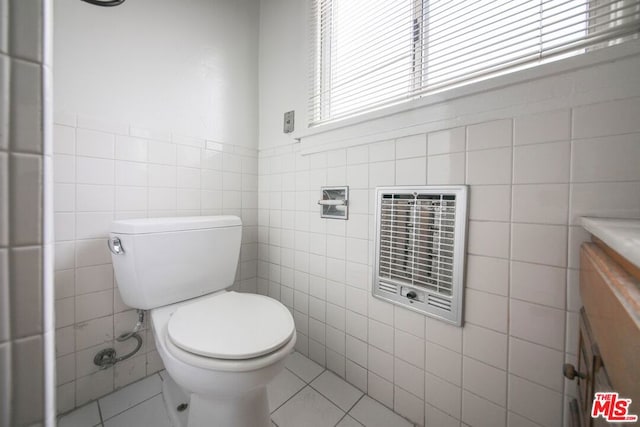 bathroom featuring vanity, heating unit, tile walls, and toilet