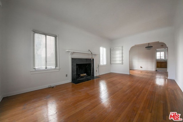 unfurnished living room featuring a fireplace, hardwood / wood-style floors, and a wealth of natural light