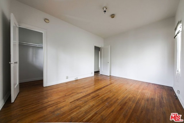 unfurnished bedroom featuring dark hardwood / wood-style flooring and a closet