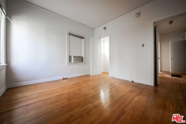 unfurnished room featuring cooling unit and hardwood / wood-style flooring