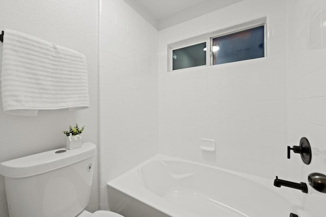 bathroom featuring bathtub / shower combination and toilet