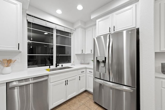 kitchen featuring white cabinetry, sink, stainless steel appliances, and light tile patterned flooring