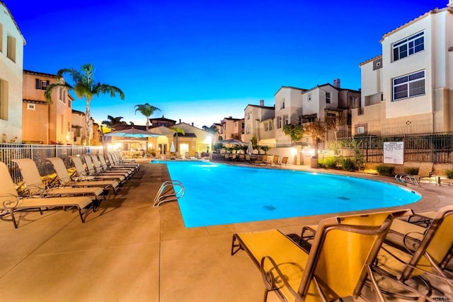 pool at dusk with a patio