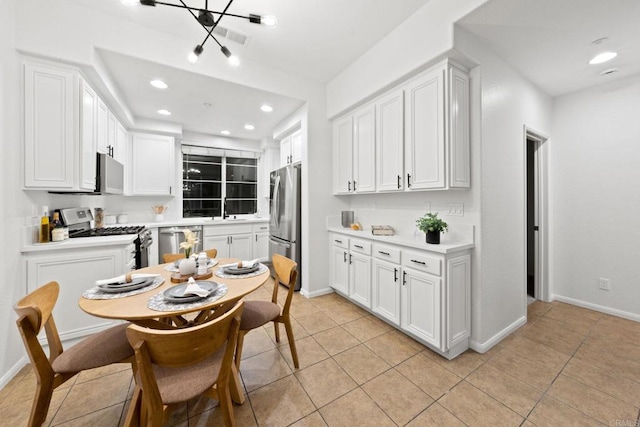 kitchen featuring stainless steel appliances, sink, light tile patterned floors, and white cabinets