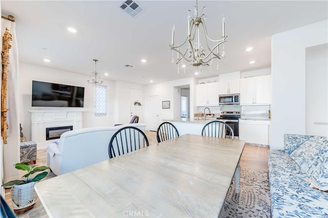 dining area featuring a chandelier and light wood-type flooring