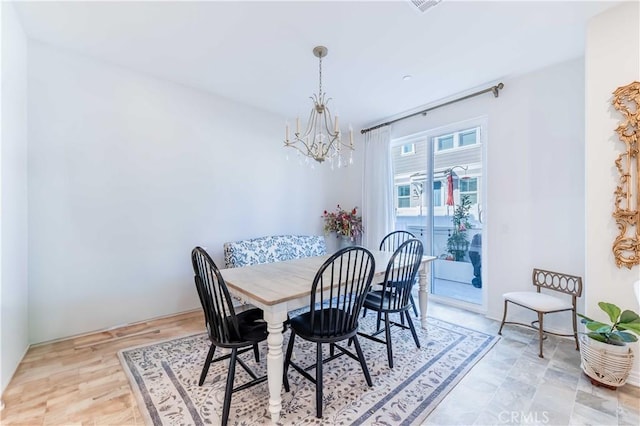 dining area with an inviting chandelier and wood-type flooring