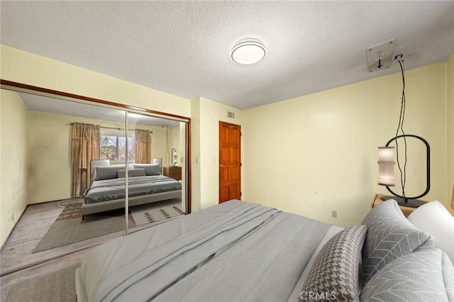 carpeted bedroom featuring a textured ceiling and a closet