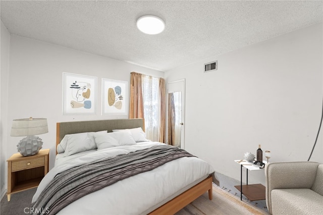 carpeted bedroom with a textured ceiling