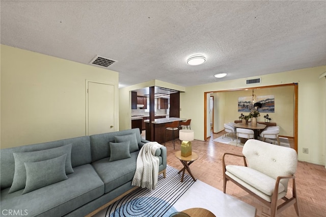 living room featuring a textured ceiling and light parquet floors