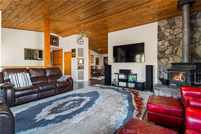 living room with wood ceiling, lofted ceiling, wood-type flooring, and a wood stove